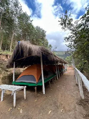 a row of tents with a straw roof at Mystic Valley Vattavada in Vattavada