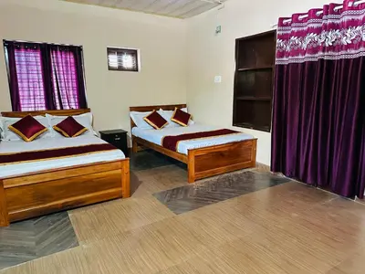 a bedroom with two beds and purple curtains at Festoon Villa in Sultan Bathery