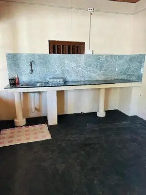 a kitchen with a counter top with a sink at Festoon Villa in Sultan Bathery