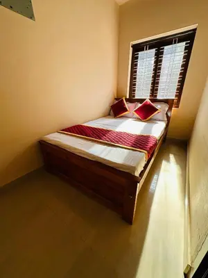 a bed with two pillows and a window in a room at Festoon Villa in Sultan Bathery