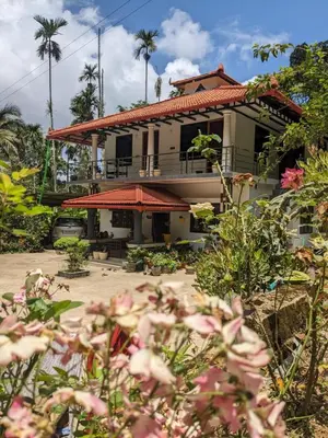 a house with a lot of flowers in front of it at Kund estate stay in Madikeri