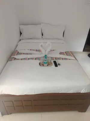 a bed with a white mattress with a bottle on it at Goldwins Grand A comfort stay in Coimbatore