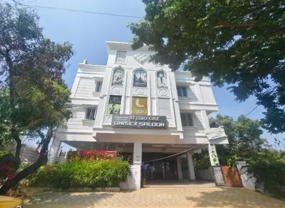a white building with a sign in front of it at Goldwins Grand A comfort stay in Coimbatore