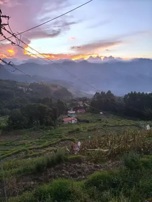 a view of a hill with a sunset in a field at Kanthalloor Mud & Mist Homestay in Kanthalloor
