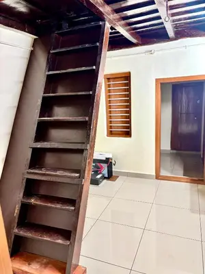a wooden staircase in a room with a wall at KODIYADAN s INN A Homestay with a Heart in Meenangadi