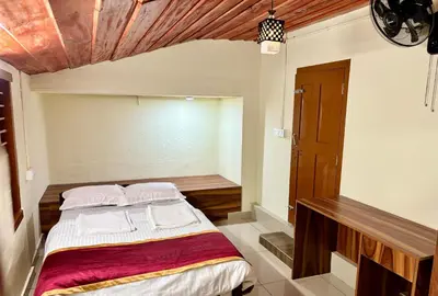 a bedroom with a bed and a wooden ceiling at KODIYADAN s INN A Homestay with a Heart in Meenangadi
