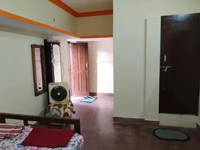 a room with a bed and a tv in it at Roopa Studio in Mysore