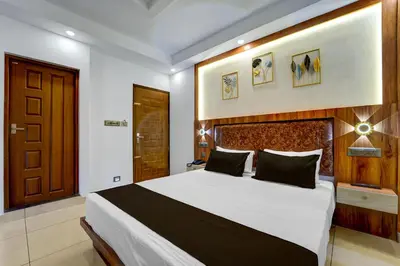 a bedroom with a large bed with a wooden headboard at Super Townhouse Cochin Airport Formerly Skyluxe in Cochin
