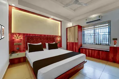a bedroom with a large bed with a red headboard at Super Townhouse Cochin Airport Formerly Skyluxe in Cochin