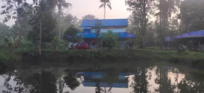 a house with a red car parked next to a body of water at Nanavu Farmhouse in Māla