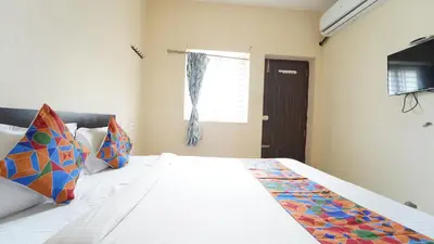 a bedroom with a large white bed with colorful pillows at Union Rooms in Coimbatore