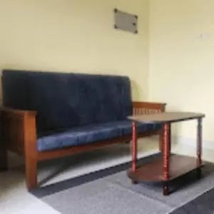a blue bench sitting in a room with a table at Sai Home Stay in Marudhamalai