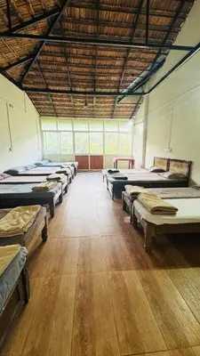 a large room with many beds in it at Hotel green land in Madikeri
