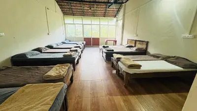 a room with a bunch of beds in it at Hotel green land in Madikeri