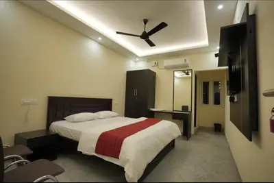 a bedroom with a bed with a ceiling fan at Keerthana Marriage hall and Rooms in Coimbatore