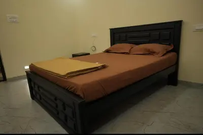 a large bed in a bedroom with a wooden headboard at Keerthana Marriage hall and Rooms in Coimbatore