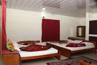 a room with two beds and a red curtain at GEE VEE Home Stay in Munnar