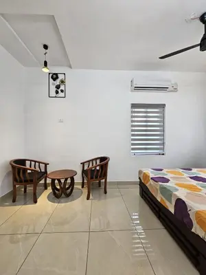 a bedroom with two chairs and a bed and a table at Dream nest beach house Resort with private beach entrance in Trichūr