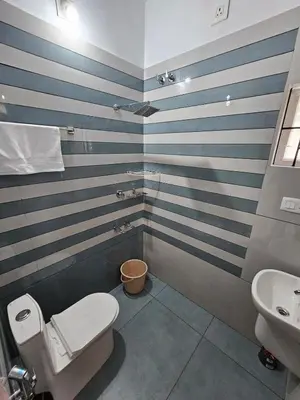 a bathroom with blue and white stripes on the wall at Dream nest beach house Resort with private beach entrance in Trichūr