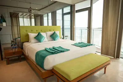 a bedroom with a large bed with green towels on it at MARINE DRIVE - BEACH FRONT LUXURY PENTHOUSE by NIOTEL in Kozhikode