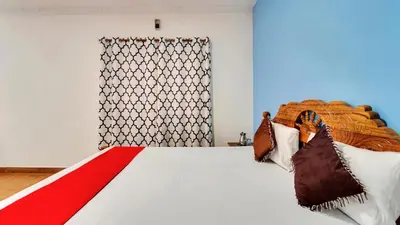 a bedroom with a bed with a red and white blanket at Coolspot Cottage in Ooty