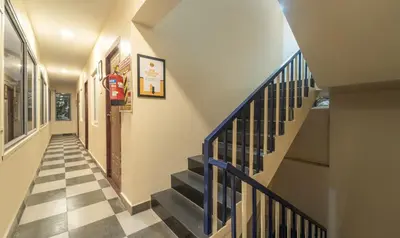 a hallway with a blue staircase with a checkered floor at Itsy Hotels Everest Leela Residency in Erode