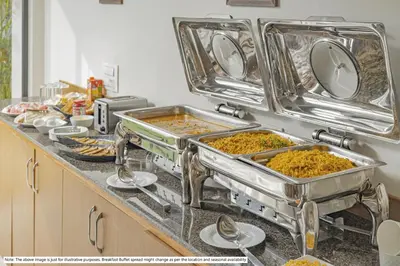 a kitchen counter with several trays of food at Itsy Hotels Everest Leela Residency in Erode