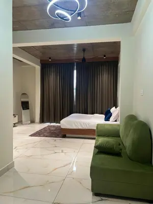 a bedroom with a bed and a green couch at Gcc Saffron in Wayanad