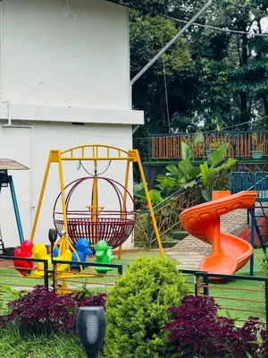 a garden with a playground with colorful swings at Gcc Saffron in Wayanad