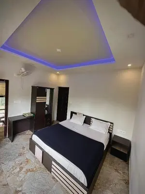 a bedroom with a bed with a blue ceiling at Gcc Saffron in Wayanad