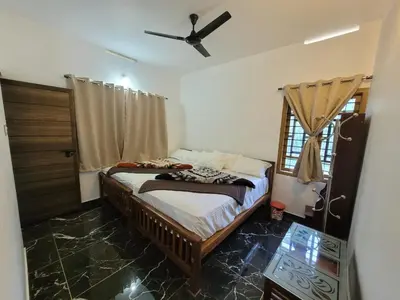 a bedroom with a bed and a ceiling fan at Wildlife Homestay in Kanthalloor