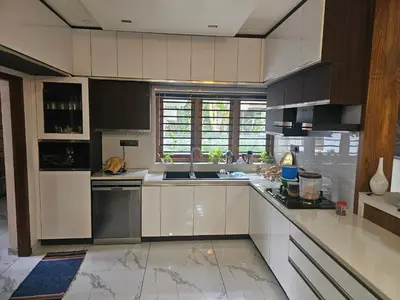 a large kitchen with white cabinets and appliances at Dreams Premium Villa in Kozhikode