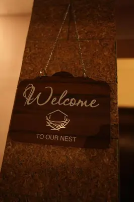 a sign that says welcome to our nest on a counter at Guruvayur Nest Homestay in Guruvāyūr