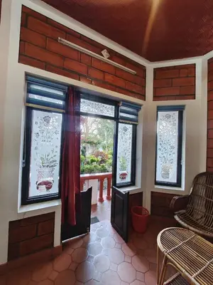 a room with windows and a table and chairs at Nasmat Resort in Masinagudi