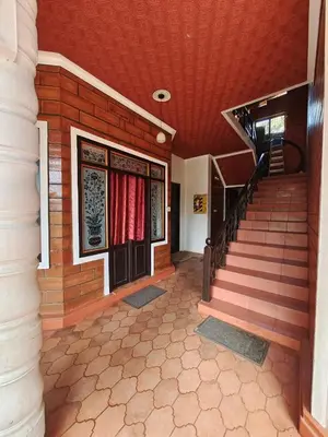 a building with a staircase and a door with red curtains at Nasmat Resort in Masinagudi