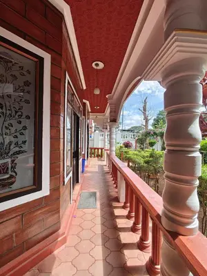 a porch of a building with columns and a painting at Nasmat Resort in Masinagudi