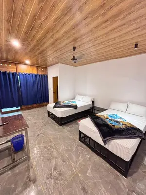 a bedroom with two beds and a wooden ceiling at Soul Stay in Munnar