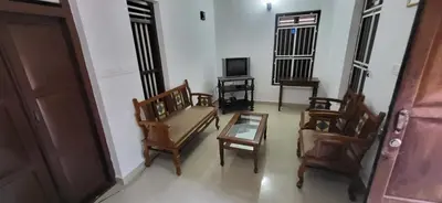 a living room with chairs and a table and a tv at Periyar Heritage in Kotamangalam