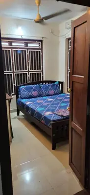 a bedroom with a bed with a blue comforter at Periyar Heritage in Kotamangalam