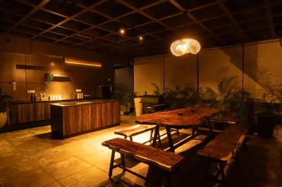 a room with a wooden table and benches in it at Vanantara - Riverside Eco Retreat in Ernakulam