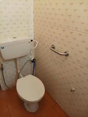a bathroom with a white toilet in a room at Shield Guest Accommodation in Pudunagaram