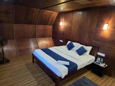a bedroom with a bed with wood paneled walls at Woodshade resort in Wayanad