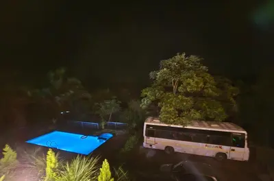 a bus parked in a parking lot next to a tree at Woodshade resort in Wayanad