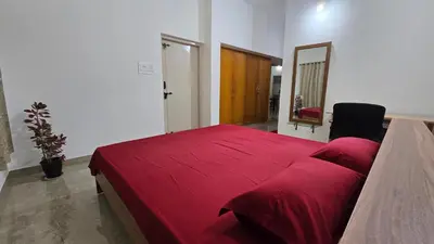 a bedroom with a red bed and a mirror at The Horalahalli House in Mysore