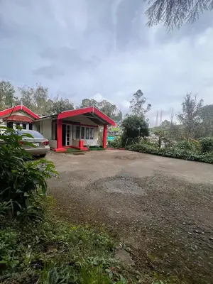 a house with a car parked in front of it at The Groot in Ooty