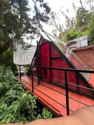 a red house with a glass dome on top of it at The Groot in Ooty