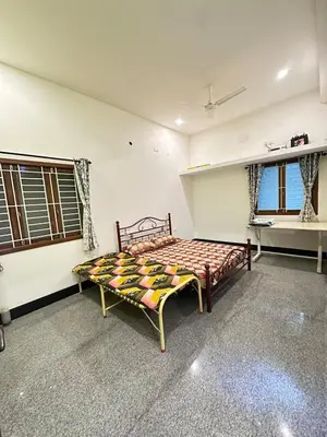 a bedroom with a bed in a room with windows at Bhargavi homes in Coimbatore