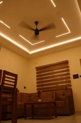 a living room with a couch and a ceiling fan at Joen homes apartment in Alwaye
