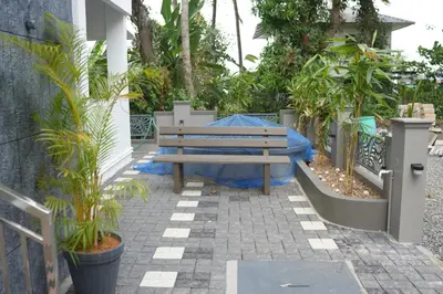 a wooden bench sitting on a patio with plants at Joen homes apartment in Alwaye
