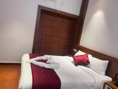 a bedroom with a bed with red and white pillows at Haveninn in Kallana
